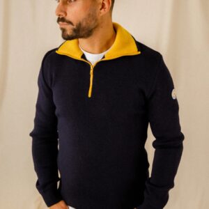 Pull camionneur Marine / Ocre porté par un mannequin en jean et t-shirt blanc