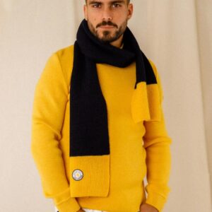 Echarpe laine bicolore Guy Cotten portée par un homme sur un pull marin jaune et un jean