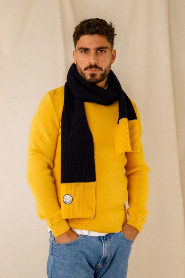 Echarpe laine bicolore Guy Cotten portée par un homme sur un pull marin jaune et un jean