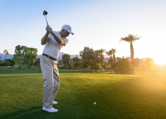 Silhouette d'un golfeur qui swingue en Chino Beige et polo blanc